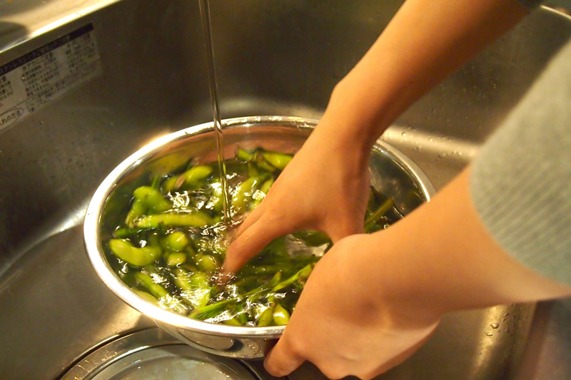 枝豆をザルで洗う