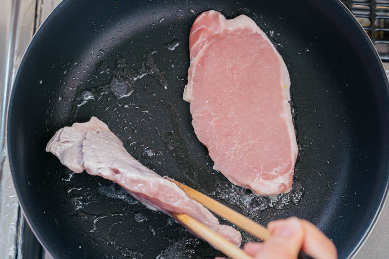 漬け込んでおいた豚肉をお箸で掴み立てるようにして焼く
