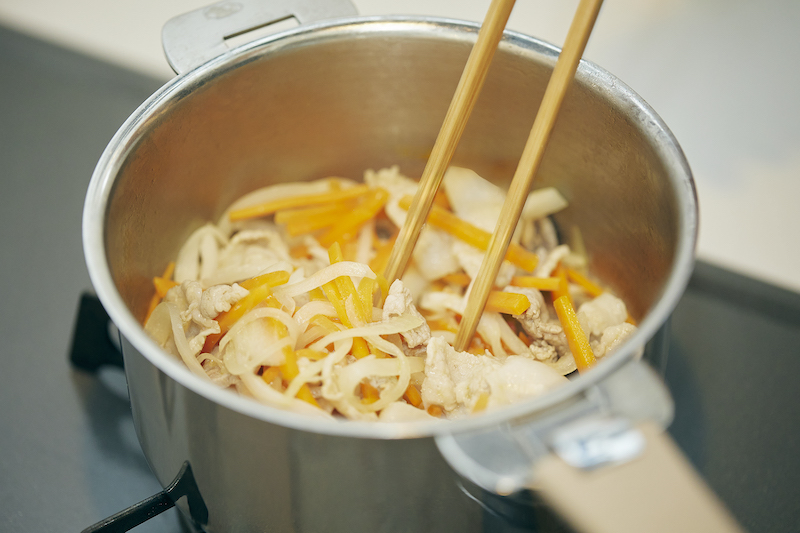 豚肉とにんじん、玉ねぎと一緒に鍋に入れて炒める